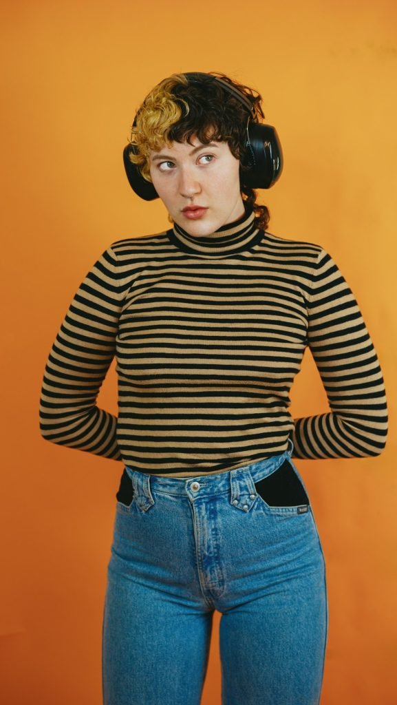 portrait-of-a-nonbinary-autistic-person-in-a-studio-setting-using-headphones-ya84k2xrz7c