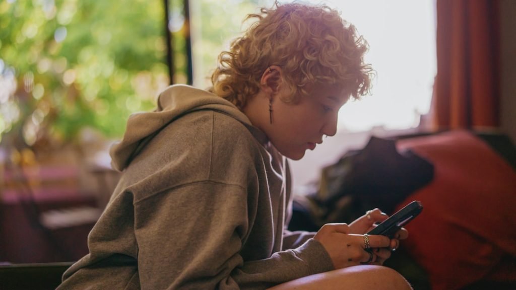 portrait-of-a-nonbinary-autistic-person-using-their-mobile-phone-indoors-vvw2wf-999g